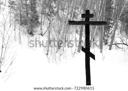 Cross on a tree in the winter forest. scary picture