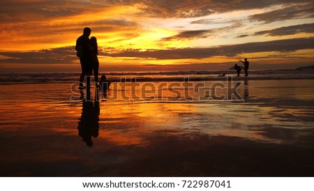 silhouette of family enjoy at the beach during sunset. 