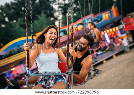 Beautiful couple having fun at luna park. Soft focus, high ISO, grainy image. Royalty-Free Stock Photo #722998996