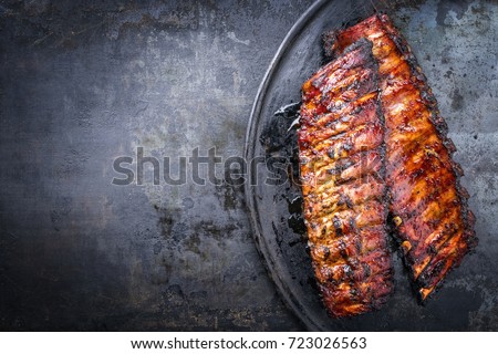 Barbecue pork spare ribs as top view on an old rustic board  Royalty-Free Stock Photo #723026563