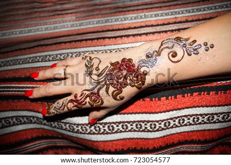 Woman hand with pattern of brown henna. Hand with mehndi. Traditional Arabic style background. Indian fashion. Selective focus.