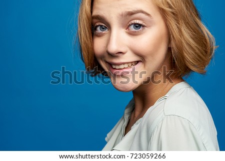 cheerful woman smiling on blue background portrait                                