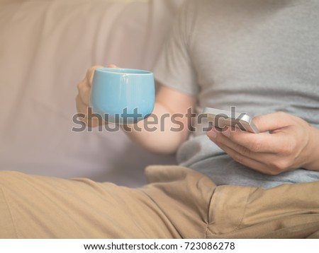 Men use cell phones and eat coffee shop.