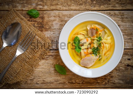 Soup with chicken and noodles.Wooden background
