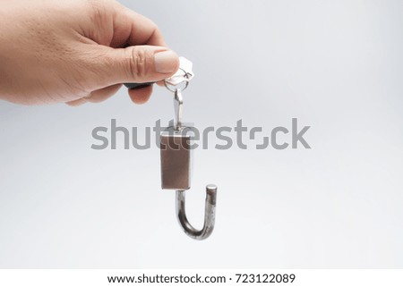 Hand holding metal lock isolated on white background