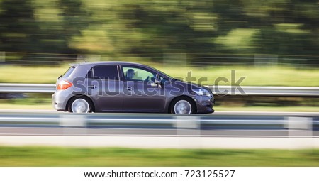 Car driving fast motion on highway side view Royalty-Free Stock Photo #723125527