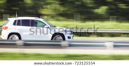 Car driving fast motion on highway side view Royalty-Free Stock Photo #723125554