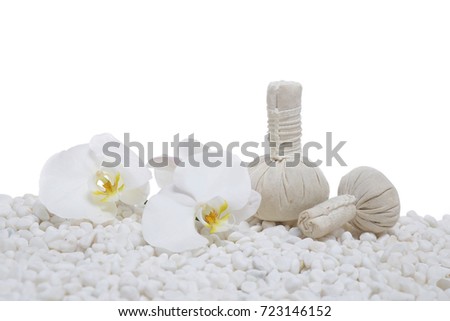White orchid with herbal ball on pile of white stones