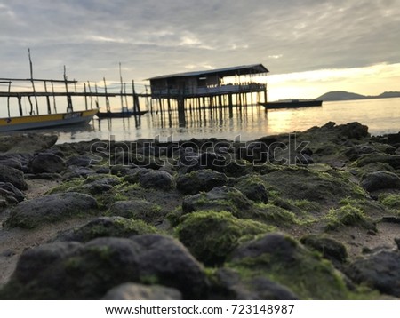 the mossy rock as foreground for the sunrise view of jetty. 