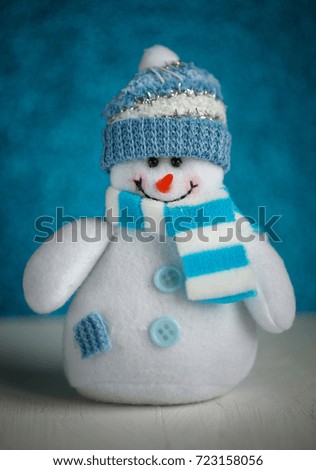 Snowman toy on blue background. Christmas and New Year decoration