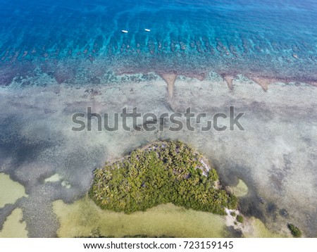 An aerial view of the barrier reef along Turneffe Atoll in Belize reveals spur and groove channels that exist near shore. This type of reef often develops on windward sides of islands. Royalty-Free Stock Photo #723159145