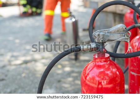 Firefighters are checking the fire extinguisher before going to work.Firefighter in action with a fire extinguisher.Red tank of fire extinguisher.