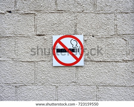 Sign - do not smoke on a white wall.