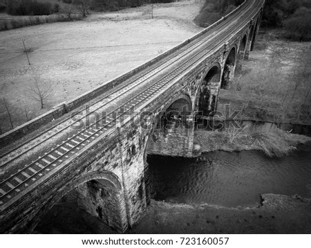Aerial view of train tracks bridge over the river.
