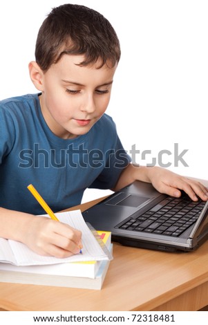 Portrait of a boy doing his homework at the laptop, isolated on white background