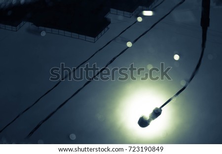 The reflection of the lamp and wires in the water surface