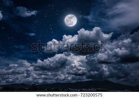Beautiful cloudscape with many stars. Night sky with bright full moon and dark cloudy above mountain range among town. Serenity nature background. The moon taken with my own camera. Royalty-Free Stock Photo #723200575