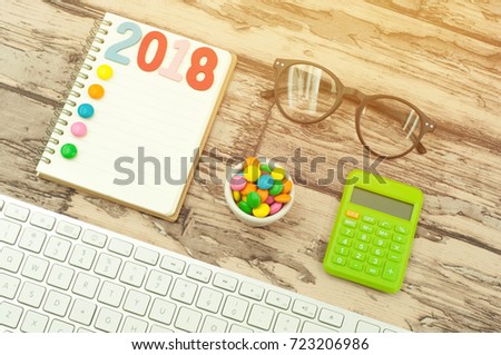 The flat lay conceptual image of 2018 new year concept with copy space on the book. To Do to, target and many more wording space at the blank page for your project. Warm tone with flare effect. 