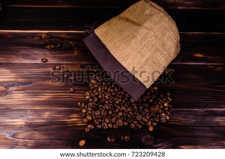 Roasted coffee beans in sack on rustic wooden table