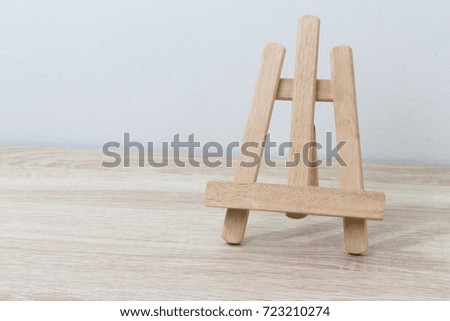 wooden easel on table background