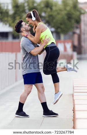 Portrait of beautiful young couple in love after running in the street.