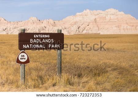 Welcome sign entering badlands national park with Rocky Mountain desert terrain and grassland
