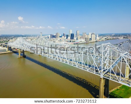 Aerial view of Crescent City Connection and riverside Downtown New Orleans again cloud blue sky. Overhead view the twin cantilever bridges across Mississippi river.