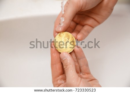 bitcoin. man washes gold coins. Concept money laundering, wash water