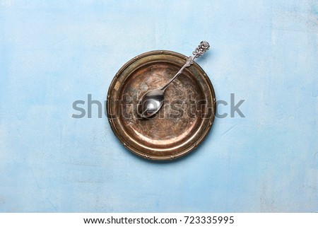Vintage plate with spoon on blue stone background