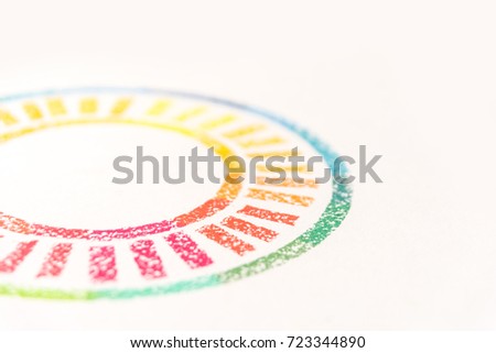 Cropped photo of circle drawn with colored pastel chalks, over white background