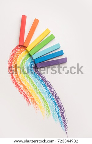 Rainbow gradient made of pastel crayon chalks over the colorful traces isolated over the white background