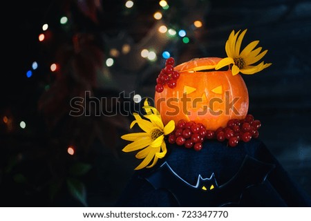 Glowing pumpkins for Halloween with yellow flowers on a dark background with . Copy the place. The horizontal frame.