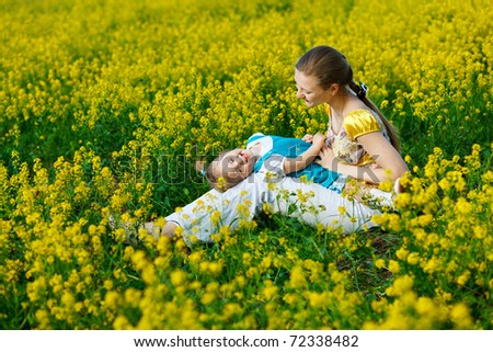 mother with baby on yellow field