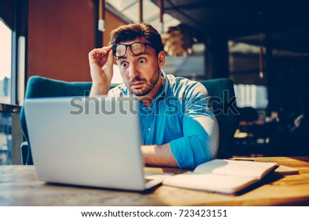 Shocked businessman getting off eyeglasses can't believe in low company income reading documents.Stressed entrepreneur doubting in receipt numbers worried about paying debt checking banking account Royalty-Free Stock Photo #723423151