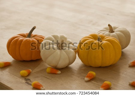 Mini pumpkins with candy corn scattered around.