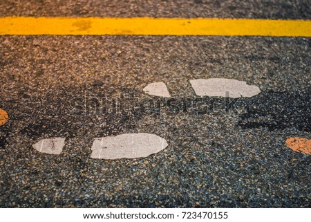 Footpath With yellow lines parallel tandem Draw a white footprint on the street.