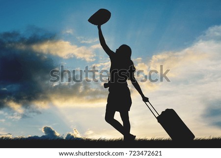 Silhouette of women travel walking with luggage at the sky sunset