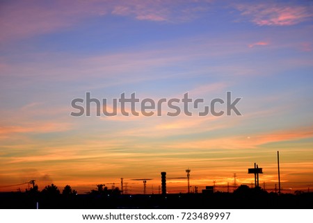 Silhouette of the electrical Pole and crane tower in Sunrise sky.