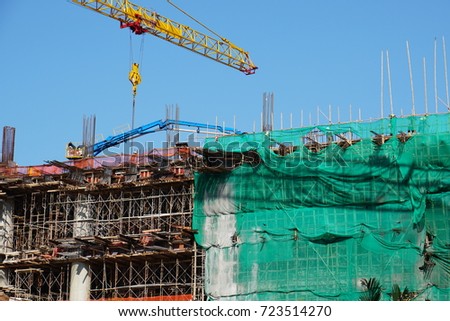 Construction site for the new hotel building with yellow crane on sunny day and blue sky