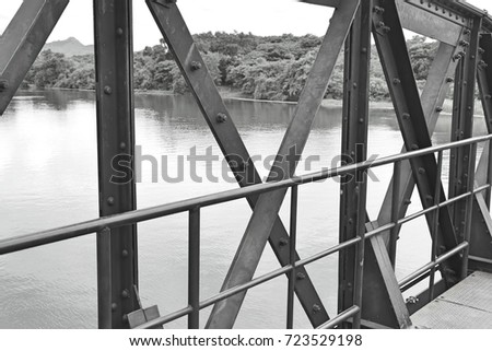 Structural elements of a steel bridge over a river in Thailand. This route was constructed by the captive in world war II. This image was blurred or selective focus. Black and white picture.