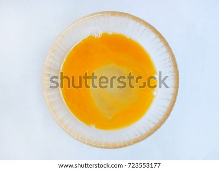 Egg yolk and white in a bowl on white background.