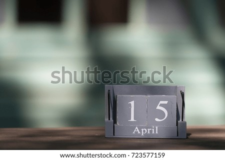 April 15th. Tax Day. Image of april 15 wooden color calendar on wooden table background. Spring day, empty space for text