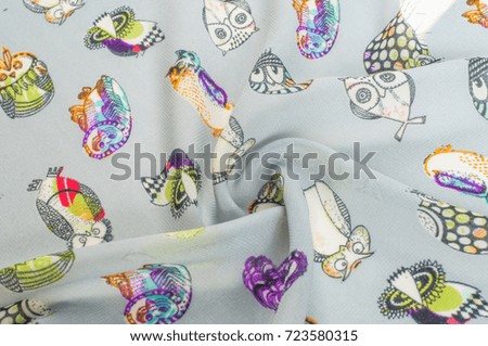 Texture, background, pattern. Silk fabric with a picture of birds, an owl, an owl.