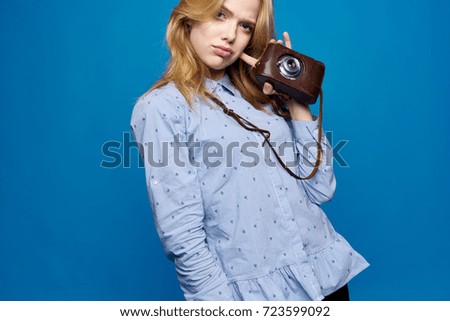 photographer woman holding a camera case on a blue background                                
