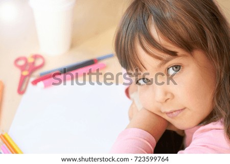 cute child in a kindergarten sitting at a table and drawing.
