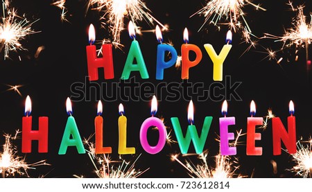 Colorful Happy Halloween candle text with sparkler fireworks, on black background
