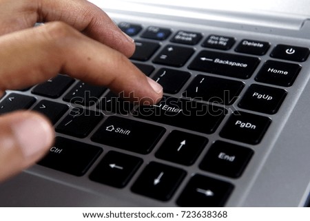 Photo of a hand on a laptop computer keyboard
