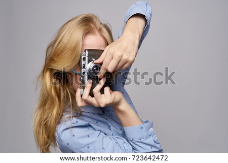photographer takes photos at the camera on a gray background                           