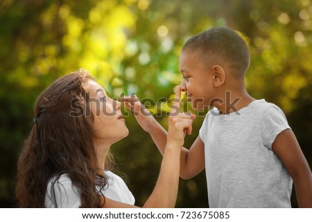 Young woman with adopted African American boy outdoors Royalty-Free Stock Photo #723675085