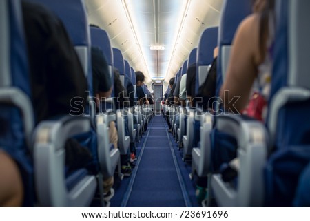 Passengers traveling by a modern commercial plane, shot from the inside of an airplane Royalty-Free Stock Photo #723691696